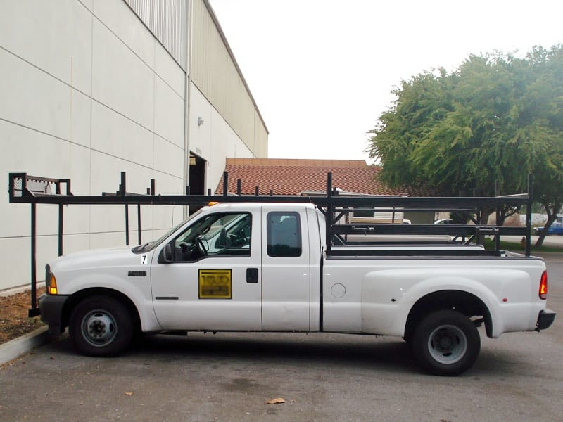 White F-350 with full bumper-to-bumper black steel ladder rack